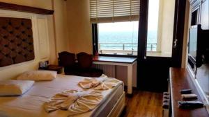 a bedroom with a bed with a desk and a window at Blue Pier Hotel in Kocaeli