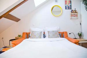 a bedroom with a large bed and orange chairs at Appartement de charme au coeur du Quartier Latin in Paris