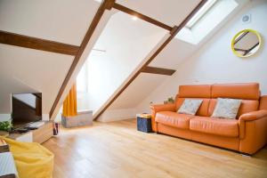 sala de estar con sofá naranja y TV en Appartement de charme au coeur du Quartier Latin en París