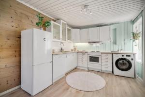 a kitchen with white cabinets and a washer and dryer at Central first floor apartment in Bergen