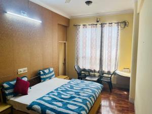a bedroom with a bed and a bathroom with a tub at Hotel Kirti Plaza in Chittaurgarh