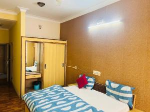 a hotel room with a bed and a mirror at Hotel Kirti Plaza in Chittaurgarh