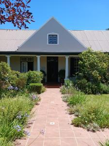a house with a walkway in front of it at Die Waenhuis Guest House in George