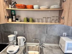 a kitchen with a sink and a counter with dishes at Peraia Studio in Perea +7 photos