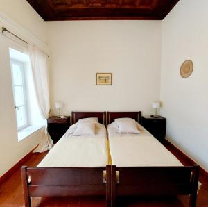 a bedroom with two beds and a window at Christina's Stone House Apartment in Hydra