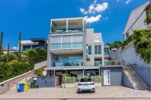 un edificio de apartamentos con un coche aparcado en la entrada en Panoramaussicht und Whirlpool im exklusiven Viertel, en Crikvenica