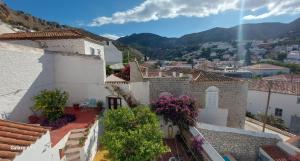 a view of a town with buildings and flowers at Christina's Stone House Apartment in Hydra