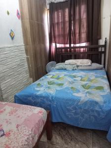 a bedroom with a bed with a blue comforter at Casinhas no Interior de MG in Antônio Prado