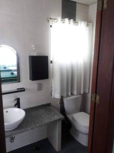 La salle de bains est pourvue de toilettes blanches et d'un lavabo. dans l'établissement Seaheart Guesthouse, à Dauis