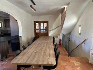 einen langen Holztisch in einem Zimmer mit Stühlen in der Unterkunft Mas des sauges in Saint-Mathieu-de-Tréviers