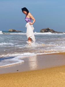 een jong meisje speelt in het water op het strand bij Ramya Ru Beach Home in Galle