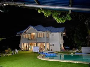a large house with a swimming pool at night at Seaheart Guesthouse in Dauis