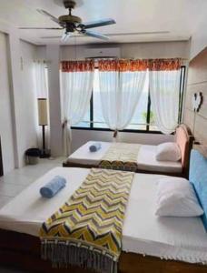 - une chambre avec 2 lits et un ventilateur de plafond dans l'établissement Seaheart Guesthouse, à Dauis