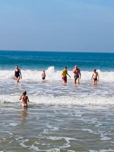 een groep mensen die in het water op het strand staan bij Ramya Ru Beach Home in Galle