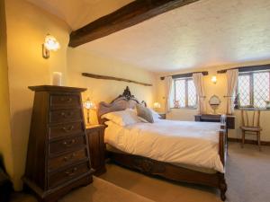 a bedroom with a large bed and a wooden dresser at 2 Bed in New Mills 75029 in Mellor