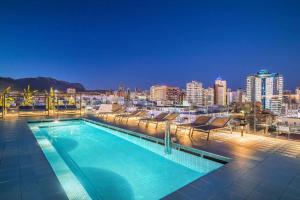 a swimming pool on top of a building with a city skyline at Barceló Benidorm Beach - Adults Recommended in Benidorm