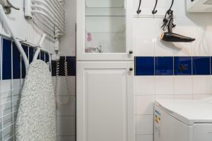 ein Bad mit blauen und weißen Fliesen und einem Waschbecken in der Unterkunft Kawiory 2/22 in Krakau