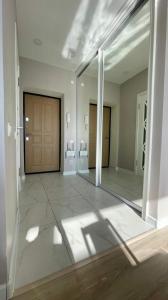 une grande pièce vide avec un miroir et une porte dans l'établissement 1-комнатные апартаменты ЖК "Саулет Курылыс", à Aqtöbe