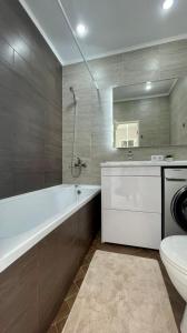 a bathroom with a tub and a toilet and a sink at 1-комнатные апартаменты ЖК "Саулет Курылыс" in Aktobe