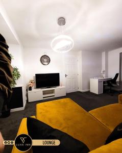 ein Wohnzimmer mit einem Flachbild-TV und einem Sofa in der Unterkunft Birmingham Airport Luxury3BRHOME in Marston Green