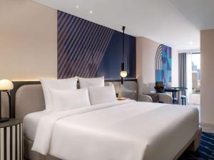 a large white bed in a hotel room at TRIBE Living Bangkok Sukhumvit 39 in Bangkok