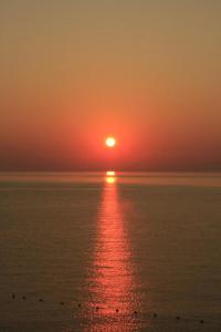 una puesta de sol sobre el océano con el sol en el cielo en Excellent views, en Marsalforn