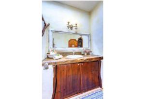 een badkamer met een houten wastafel en een spiegel bij Can Piedrópolis in Cala Saona +37 foto's