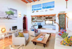 a living room with two couches and a table at Can Piedrópolis in Cala Saona