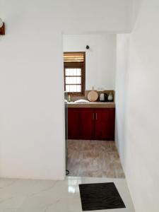 a kitchen with red cabinets and a sink at Unic Residence And Transit Hotel in Katunayake