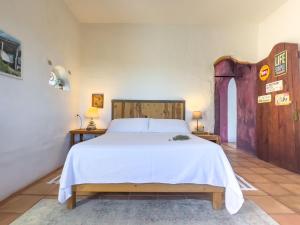 a bedroom with a large bed with white sheets at Can Piedrópolis in Cala Saona