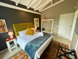 a bedroom with a large bed and a mirror at Calm Waters Guesthouse: Robberg Room in Plettenberg Bay