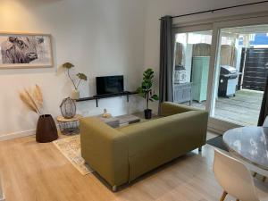 uma sala de estar com um sofá verde e uma mesa em Waltrilo em Waalre