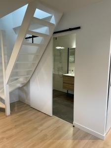 een kamer met een trap en een badkamer met een wastafel bij Waltrilo in Waalre