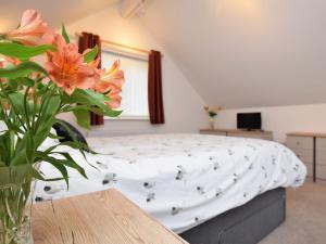 a bedroom with a bed with a vase of flowers at 4 Bed in Northam 53701 in Northam