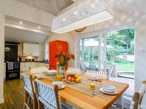 a kitchen and dining room with a wooden table and chairs at 4 Bed in Westward Ho 66659 in Northam