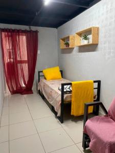 a bedroom with a bed and a red curtain at quintal293 in Recife