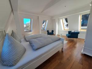 a bedroom with a large white bed with blue pillows at Penthouse über den Dächern Badenweilers in Badenweiler