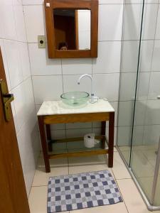 a bathroom with a glass sink and a mirror at quintal293 in Recife