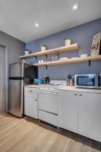 a kitchen with white appliances and a blue wall at Budget friendly studio apt in historic Springfield in Jacksonville