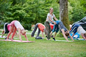 een groep mensen die yoga doen in het gras bij Apartments am Camping Dornbirn in Dornbirn