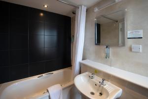 a bathroom with a sink and a bath tub at The Royal Hop Pole Wetherspoon in Tewkesbury