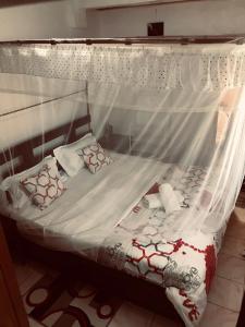 基蘇木的住宿－Stone Island，一张带白色床单和枕头的天蓬床