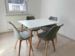 einen weißen Tisch und 4 Stühle in einem Zimmer in der Unterkunft Double Room in the black Forest in Villingen-Schwenningen