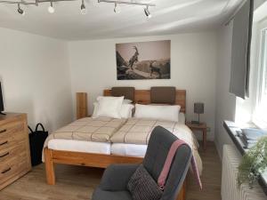 a bedroom with a bed and a chair at Ferienwohnungen Mews in Immenstadt im Allgäu