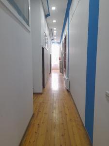 an empty hallway in an office building with a wooden floor at White city hostel in Baku
