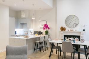 Urban Chic - Acre في لندن: مطبخ وغرفة معيشة مع طاولة وكراسي