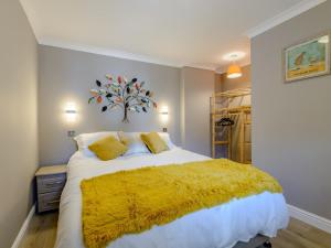 a bedroom with a large bed with a yellow blanket at 1 Bed in 78725 in Tanfield