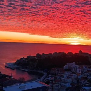 una puesta de sol sobre el océano y una ciudad en Apartments Radoman, en Ulcinj