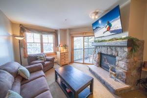 a living room with a fireplace with a tv above it at Buffalo Lodge 8361 in Keystone