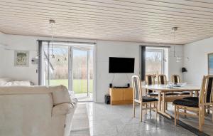 a living room with a table and a tv at Cozy Home In Sydals With Kitchen in Skovbyballe